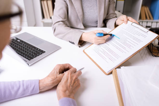 istock Hands of insurance agent underlining important phrase in document 1210589493