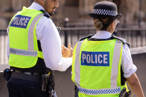 des policiers métropolitains asiatiques mâles et féminins patrouillent la foule des touristes devant les hoses du parlement à westminster, londres, royaume-uni - england europe london england uk photos et images de collection