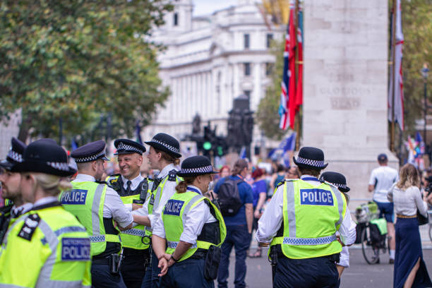 Happy laughing group of metropolitan police officers patrols the crowds of tourists in Whitehall in Westminster, London, UK stock photo