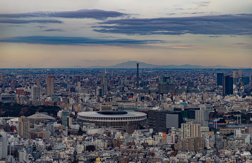 A picture of the Tokyo cityscape, showing the New National Stadium, at sunset.