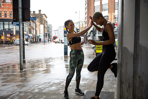 Women exercising outdoors in the city street in a rainy day in London