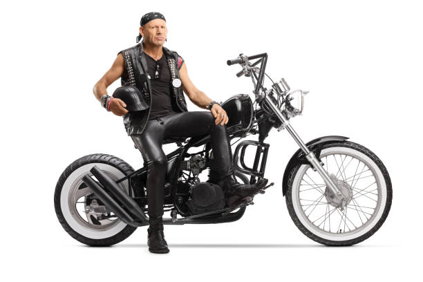istock Biker holding a helmet and sitting on a custom chopper 1210593032