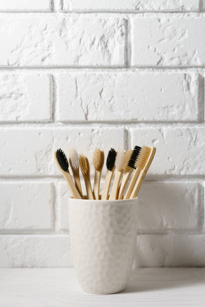 istock A white ceramic glass with biodegradable bamboo toothbrushes stands against a brick wall. Zero waste concept. 1210598540