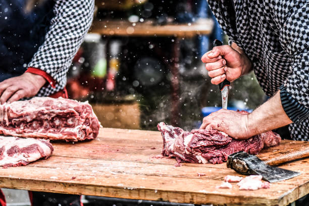 Butcher cutting raw meat.