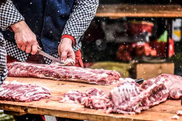 Butcher cutting raw meat.