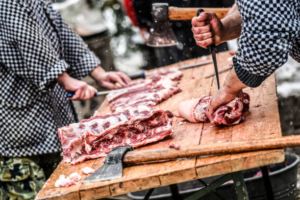 Butcher cutting raw meat.