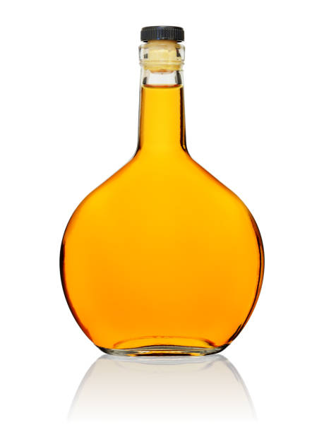 istock Glass bottle of brandy, closed with a cork on a white background with a reflection. 1210603453
