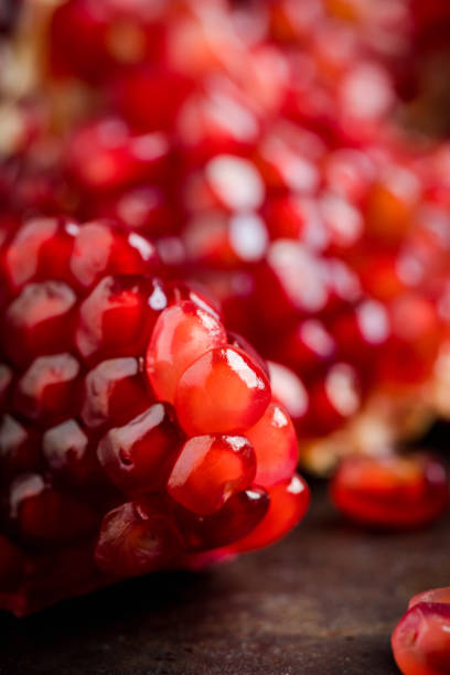 istock Broken red ripe pomegranate fruit on the dark rustic background 1210604114
