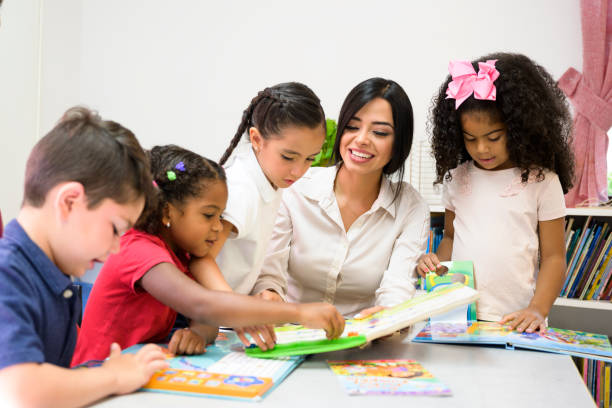 istock Hispanic teacher and young students enjoying picture books 1210604291