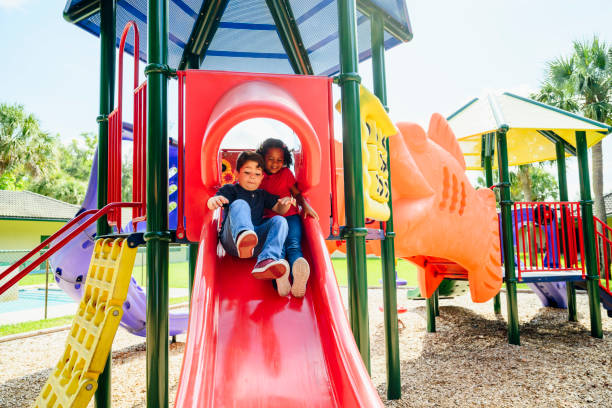 istock Young Hispanic classmates sliding together during recess 1210604319
