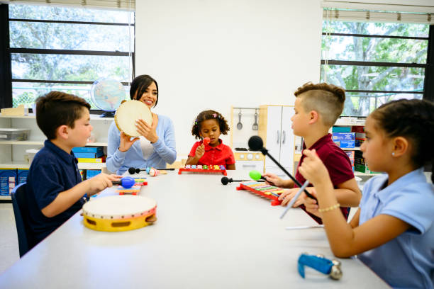 istock Hispanic schoolteacher and young students with instruments 1210604328