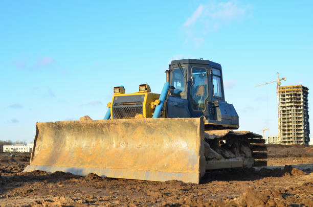 istock Bulldozer during land clearing and foundation digging at large construction site. Crawler tractor with bucket for pool excavation and utility trenching. Dozer, Earth-moving equipment. 1210604545