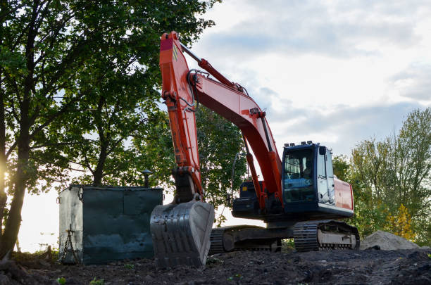 Bucked tracked excavator digs ground at a construction site for installing concrete storm pipes. Backhoe the digging pipeline ditch. Commercial and Public Civil Work Contracting, trenching, tamps soil excavadora rastreada abrochado cava tierra en un sitio de construcción para la instalación de tuberías de tormenta de hormigón. retroceda la zanja del oleoducto de excavación. contratación de obra civil comercial y pública, zanja, suelo de tampones