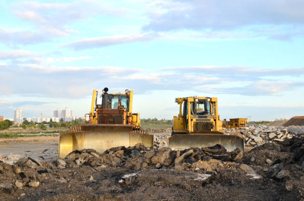 Yellow bulldozer at a loamy construction site, partly isolated in white back