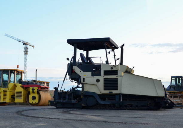 istock Asphalt paver machine and road roller working at construction site during asphalt road repair. Paving roller machine on paving works. 1210604901
