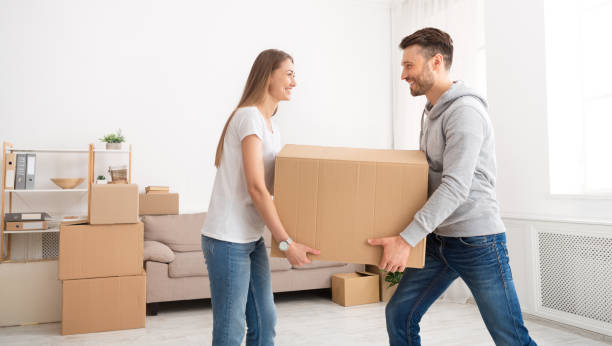 istock Happy young couple moving in new flat with cardboard boxes 1210609167