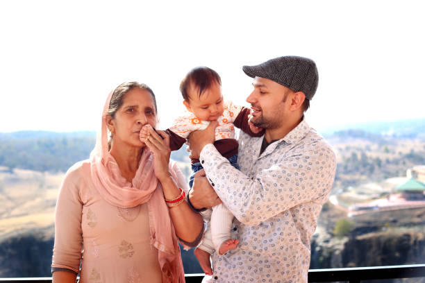 istock Father holding baby and standing with mother 1210618892