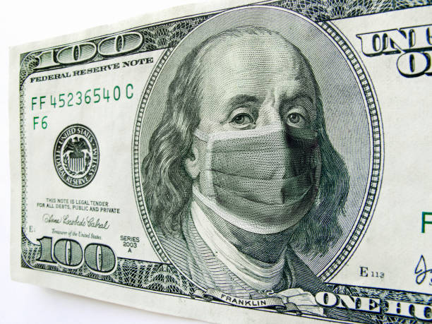 Ben Franklin wearing a Coronavirus Healthcare Mask on One Hundred Dollar Bill. This photo illustration of Ben Franklin wearing a healthcare surgical mask on a one hundred dollar bill illustrates the Coronavirus, the protection of wearing a mask during international travel, and economic costs affecting business, transportation, travel, and commercial airlines. benjamin franklin photos stock pictures, royalty-free photos & images