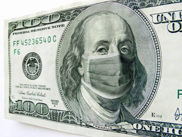 Ben Franklin wearing a Coronavirus Healthcare Mask on One Hundred Dollar Bill. This photo illustration of Ben Franklin wearing a healthcare surgical mask on a one hundred dollar bill illustrates the Coronavirus, the protection of wearing a mask during international travel, and economic costs affecting business, transportation, travel, and commercial airlines. unemployment stock pictures, royalty-free photos & images