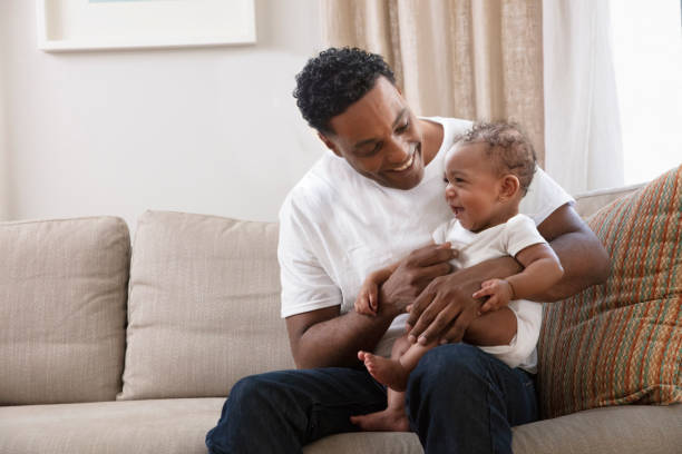 istock Father playing with his daughter sitting at the sofa 1210620401