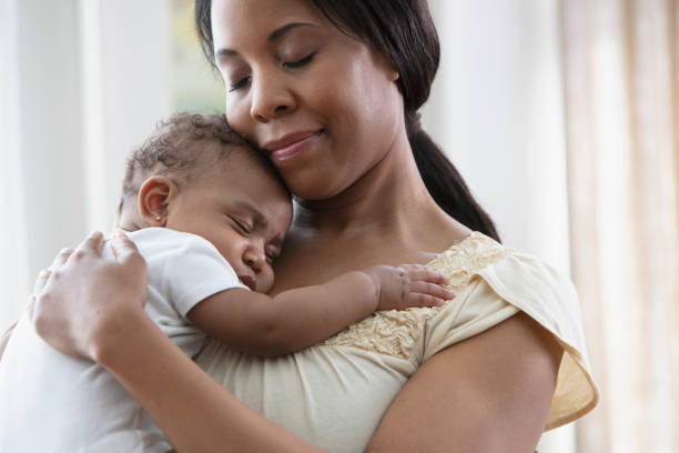 istock Mother holding her sleeping daughter 1210620482