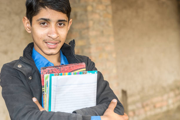 istock a young student wearing school uniform and holding books and feeling happy 1210620588