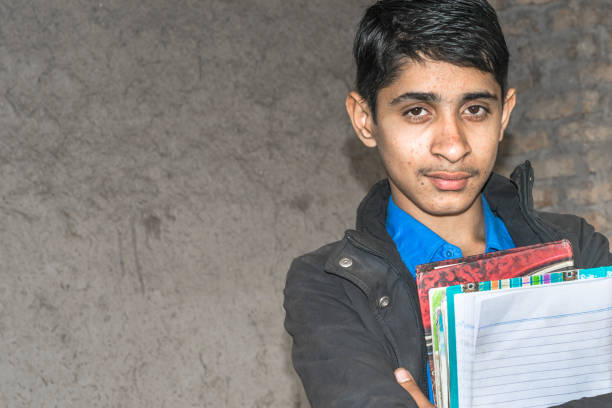 istock a young student wearing school uniform and holding books and feeling happy 1210620618