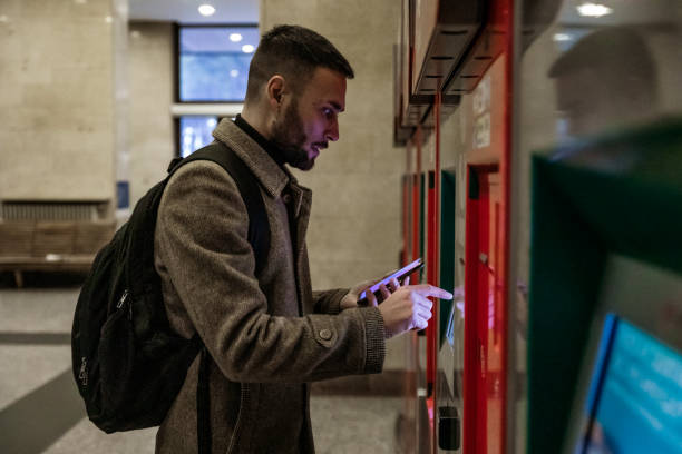 istock Handsome Young Man Using Ticket Machine at Train Station - Stock Photo 1210626833