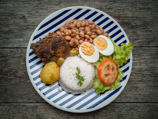 Food dish. Beans, rice, meat, salad, egg. Rustic wood background. Flat Lay.