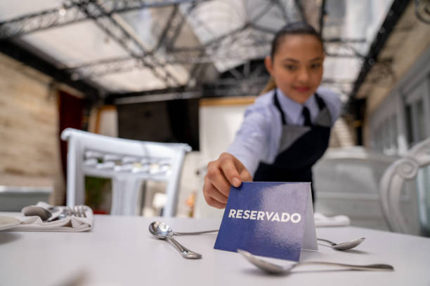 istock Waitress working at a restaurant putting a reserved sign on a table 1210628804
