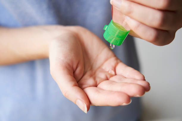 istock Woman squeezing sand sanitizer onto her hands from bottle 1210631349