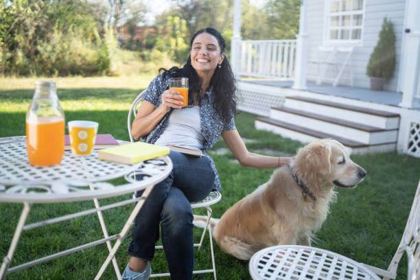 istock Woman sitting in back yard drinking orange juice and resting 1210631687