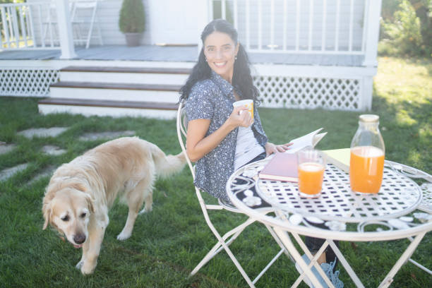 istock Woman sitting in back yard drinking orange juice and resting 1210631690