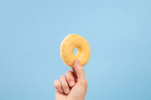 Man hand hold a glaze donut with copy space