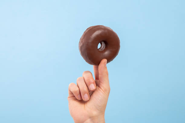 Man hand hold a chocolate donut with copy space