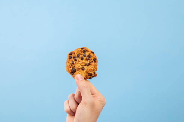istock Man hand hold a cookie with toppings with copy space 1210631707