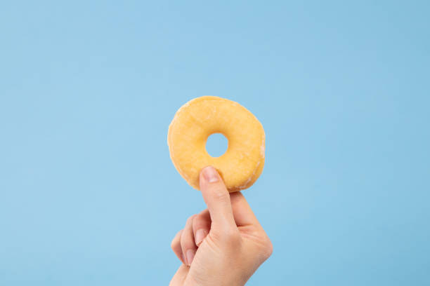 istock Man hand hold a glazed donut with copy space 1210631709