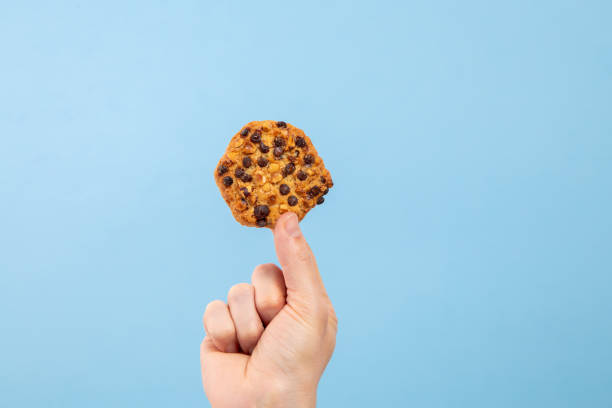 istock Man hand hold a cookie with toppings with copy space 1210631711
