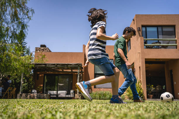 istock Lively young boys playing soccer in their home back yard 1210634787