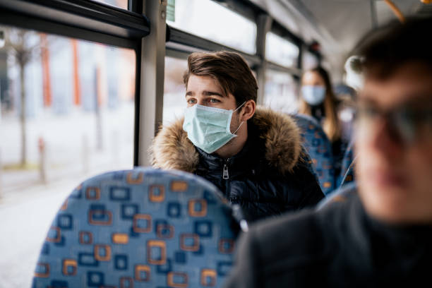 istock Young male wearing protective face mask while traveling with public transport 1210636682