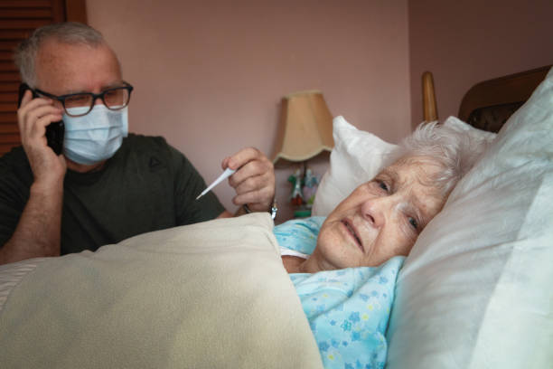 senior mann ruft eine helpline, während sein partner krank ist - couple senior adult sadness emotional stress stock-fotos und bilder