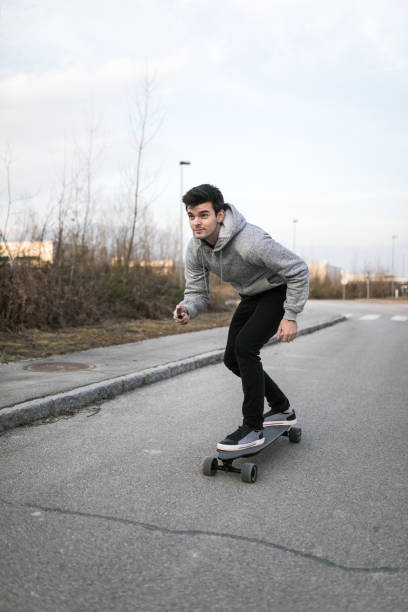 istock Man on a electric skateboard on an empty road 1210641530