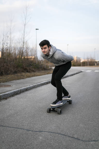 istock Man on a electric skateboard on an empty road 1210643241