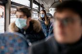 Young girl wearing sterile face mask using a public transport