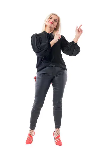 Happy satisfied middle aged lady well dressed woman pointing finger up showing empty space. Full body length isolated on white background.