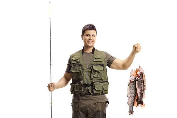istock Fisherman posing with a fishing rod and trout fish 1210649411