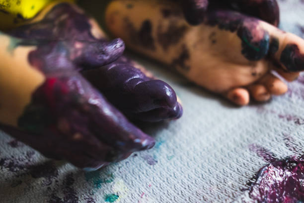 istock Little kid hands and feet covered with multiple colours 1210652488