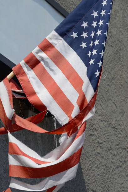 istock American flag on flag pole torn and divided 1210653583