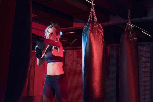 istock Powerful Female Boxer fight with sandbag 1210654324