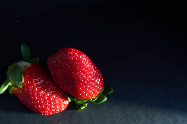 istock strawberries with natural light and black background 1210654522